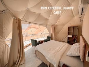 a bedroom in a tent with a bed and a window at RUM CHEERFUL lUXURY CAMP in Wadi Rum