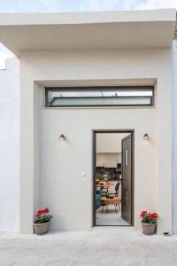 uma casa branca com dois vasos de plantas na frente de uma porta em Ontas apartment in Kissamos em Kissamos