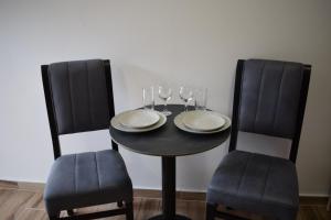 卡萨米尔Sunset Cottage 2的一张带两把椅子的黑桌和酒杯