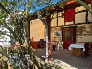 a patio with a red door and a table and chairs at Mecklenburg Vorpommern in Neukalen