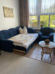 a living room with a blue couch and a table at Mecklenburg Vorpommern in Neukalen