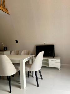 a dining room with a table and chairs and a tv at A Frame Lerik in Lerik