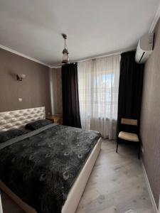een slaapkamer met een bed, een stoel en een raam bij Видовая 1 ком на Осокорках in Kiev