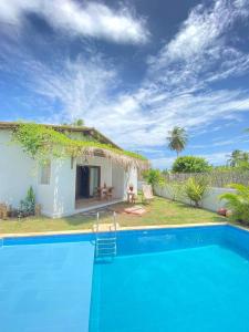 eine Villa mit einem Pool vor einem Haus in der Unterkunft Pontal da Enseada in Pôrto de Pedras