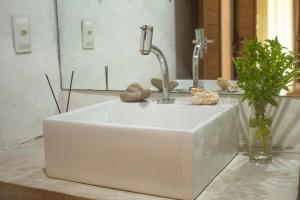 ein weißes Waschbecken mit einem Wasserhahn im Bad in der Unterkunft Pontal da Enseada in Pôrto de Pedras