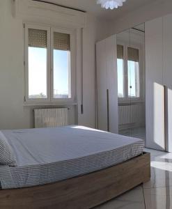 ein großes Bett in einem weißen Zimmer mit Fenstern in der Unterkunft Ritiro sul fiume Mantova, Cremona Circuit in Canneto sullʼOglio