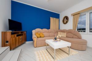 a living room with a couch and a tv at Apartments Kos in Supetarska Draga