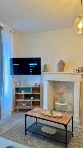 salon ze stołem i kominkiem w obiekcie Maison 1 chambre centre-ville cosy w mieście Ruelle-sur-Touvre +2 zdjęcia