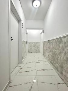 an empty corridor with white walls and a tile floor at GlassRoom- Самостоятелна стая Private room in Varna City