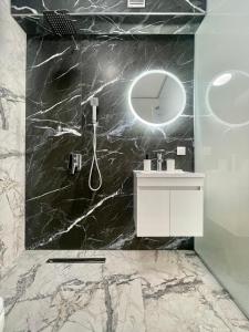a black marble bathroom with a sink and a mirror at GlassRoom- Самостоятелна стая Private room in Varna City