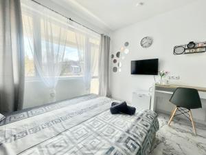 a bedroom with a bed and a window and a desk at GlassRoom- Самостоятелна стая Private room in Varna City