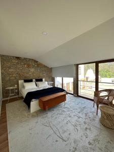 a bedroom with a bed and a stone wall at Casa do Forno de Cal in Vila do Conde