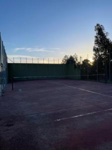 um campo de ténis vazio com uma cerca ao fundo em Apartamento Ultreia - Estorde em Cee