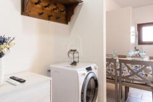 una lavadora y secadora blancas en una habitación en il gabbiano castelsardo, en Castelsardo