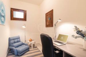Habitación con escritorio, ordenador portátil y silla. en il gabbiano castelsardo, en Castelsardo
