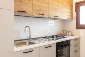 uma cozinha com um lavatório e um fogão em il gabbiano castelsardo em Castelsardo