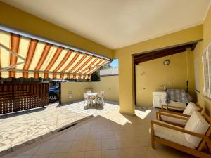 ein Wohnzimmer mit gelben Wänden und einer Terrasse in der Unterkunft Villetta Anzio Cincinnato in Anzio