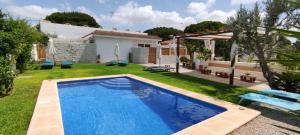 a backyard with a swimming pool and a house at La Calita Escondida - Jacuzzi y Cocina en Terraza Privada - Piscina y Parking Gratis in Chiclana de la Frontera