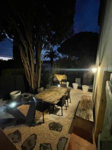 a patio with a wooden table and chairs at night at Appartement plein centre avec jardin in Saint-Tropez