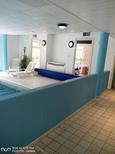 a swimming pool in a house with a blue wall at Le Repaire du Golfeur de la Largue - Mooslargue in Mooslargue