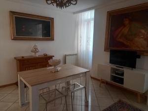 a living room with a table and a tv at Maison Santa Giustina in Salò