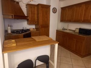 a kitchen with wooden cabinets and a wooden counter top at Maison Santa Giustina in Salò