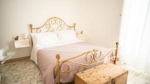 a white bedroom with a bed with a wooden bench at Pupi Catania Etna B&B - #viaggiosiciliano in Catania
