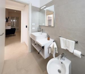 Baño blanco con lavabo y aseo en Maruzza Home en Favignana