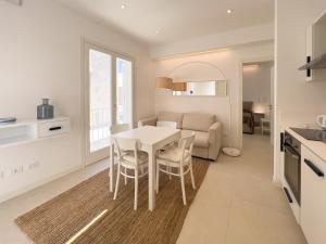 una cucina e un soggiorno con tavolo e sedie bianchi di Maruzza Home a Favignana