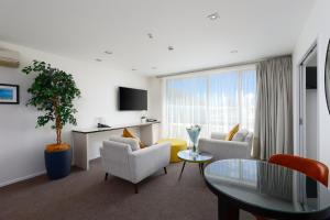 a living room with a couch and chairs and a table at Palazzo Motor Lodge in Nelson