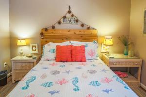 a bedroom with a bed with a wooden headboard at Mermaid’s Folly in Folly Beach