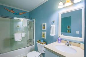 a bathroom with a sink and a shower and a toilet at Mermaid’s Folly in Folly Beach