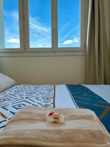 1 cama con 2 toallas y ventana en Chambre privée dans un appartement partagé en Villeurbanne