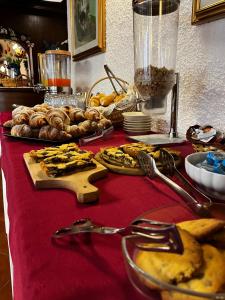 uma mesa com uma toalha de mesa vermelha com comida em Hotel Miravalle em Imer