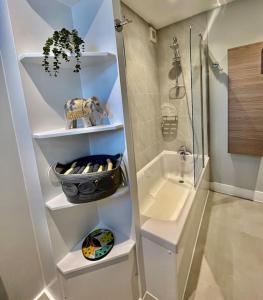 ein Bad mit einer Dusche und einem Waschbecken in der Unterkunft Entire 3 Bed House Weybridge Brooklands, London in Byfleet