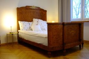 Schlafzimmer mit einem Bett mit einem Kopfteil aus Holz in der Unterkunft Meta Biblioteka in Puławy