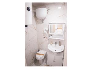 a white bathroom with a sink and a toilet at Historical Center Porto Suite in Naples