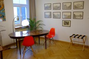 ein Esszimmer mit einem Tisch und roten Stühlen in der Unterkunft Meta Biblioteka in Puławy