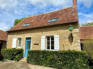 a brick house with a blue door at Maison avec piscine au calme 