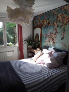Schlafzimmer mit einem Bett mit Blumentapete in der Unterkunft LES BIGORNEAUX in Saint-Suliac