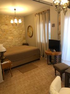 ein Schlafzimmer mit einem Bett und einem Tisch mit einem TV in der Unterkunft Hospitality M7 in Kallithea (Chalkidiki)