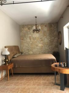 1 dormitorio con cama y pared de piedra en Hospitality M7, en Kallithea Halkidikis