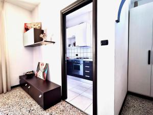 a room with a mirror and a table and a kitchen at Casa da Ste in Mandello del Lario