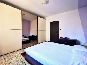 a bedroom with a large white bed and a mirror at Casa da Ste in Mandello del Lario