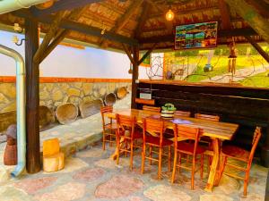 Boljevac的住宿－Etno selo Stanojevic，一间带木桌和椅子的用餐室