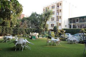 a group of chairs and tables in a park at Indira International Inn in New Delhi