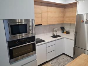 a kitchen with white cabinets and a stainless steel appliance at BST Batumi Leo in Angisa