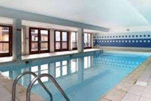 une grande piscine dans un immeuble dans l'établissement T2 6 p - Pieds des pistes - résidence avec piscine, à Orcières
