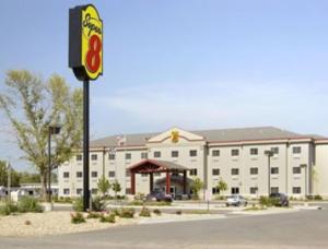 a large white building with a gas station in front of it at Super 8 by Wyndham Topeka at Forbes Landing in Topeka