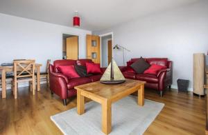 a living room with two red couches and a table at The Lantern Building in Southampton